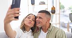 Couple, selfie and smile on living room sofa in home for love, bond or kiss with comic laugh for blog. Man, woman and happy for memory, profile picture and photography for social media app in house