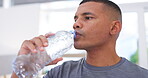 Fitness break, thirsty and a man drinking water after exercise for hydration, health and wellness. Sports, healthy and a male athlete with a drink after training, exercise or a workout in a house