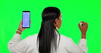 Woman, back and phone mockup writing on green screen for planning against a studio background. Rear view of female person thinking on chromakey space or mobile smartphone display and tracking markers