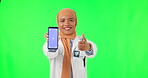 Muslim woman, doctor and thumbs up with phone on green screen for success against a studio background. Portrait of female medical or healthcare expert with like emoji, smartphone and tracking markers