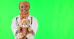 Teddy bear, face of doctor and Muslim woman on green screen in studio isolated on a background mockup. Gift, portrait and happy medical professional with charity toys, present and funny pediatrician.