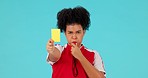 Whistle, yellow card and woman referee in a studio with rules for a football match, game or tournament. Sports, fitness and portrait of female soccer coach with equipment isolated by blue background.