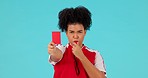 Whistle, red card and female referee in a studio with rules for a football match, game or tournament. Sports, fitness and portrait of a woman soccer coach with equipment isolated by a blue background