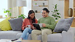 Tablet, sofa and happy couple with coffee, relax and talking, conversation or planning life together at home. Living room, tea or drink of interracial woman and partner on couch and digital streaming