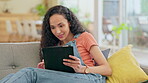 Technology, woman on her tablet and thinking on sofa in living room of her home. Connectivity or online communication, social media and happy female person with an idea on her couch of her house