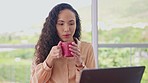 Woman, drinking coffee and working on laptop in home office for digital planning, online research or administration. Female employee with hot drink in mug at computer, internet and technology at desk