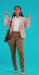 Face, happy and business woman pointing up in studio isolated on a blue background. Mockup, presentation and person with hand gesture in portrait for marketing, advertising and space for commercial.