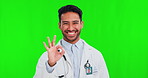 Perfect, green screen and portrait of doctor with review, agreement and success sign isolated in a studio background. Yes, like and man medical professional or healthcare worker with happy smile