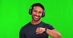 Man, checking watch and green screen portrait with smile, workout success and yes from fitness goals. Headphones, male person and happy with exercise time, step count and heart monitor with stopwatch