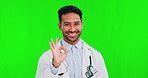 Perfect, green screen and portrait of doctor with ok, agreement and success sign isolated in a studio background. Smile, happy and man professional or healthcare worker with medical review or like