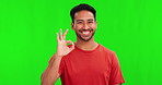 Okay sign, face and man on green screen for success, certified and excellence in casual clothes or tshirt. Happy young, asian person with yes or OK emoji and hand for agreement on studio background