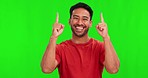 Pointing up, happy and face of Asian man on green screen for promotion, branding and selection. Advertising, hand gesture and portrait of excited male person for deal, news and announcement in studio
