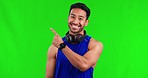 Fitness, pointing and man in a studio with green screen for marketing, promotion or advertising. Sports, athlete and portrait of a happy male person with a presenting gesture by chroma key background