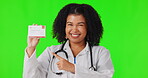 Pointing, green screen or happy woman doctor with business card for advertising healthcare. Portrait, face or excited nurse with hand gesture to show promotion offer, deal or information in studio