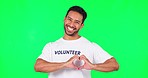 Heart, happy and man in a studio with green screen with a wink face expression fro flirting. Happiness, smile and portrait of a male model with a love hand gesture isolated by a chroma key background