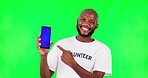 Black man, point at phone and mockup, green screen and volunteer, community service with app on studio background. Website sign up, register for charity work and male person help and tracking marker