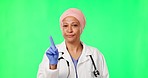 Doctor, woman and finger for no by green screen for warning, advice and consulting in mock up. Islamic medic, index and face for icon, sign language and disagree in healthcare, wellness or clinic job