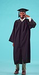 Graduation, call gesture and man in a studio for university success, achievement or goal. Happy, smile and young African male college graduate with a phone hand sign isolated by a blue background.