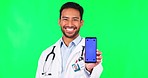 Asian man, doctor and phone mockup on green screen in advertising against a studio background. Portrait of male person, medical or healthcare professional with smartphone display and tracking markers