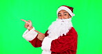 Christmas, Santa and presentation with man on green screen for pointing, idea and show.  Deal, advertising and space with portrait of person on studio background for xmas, festive and holiday season