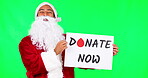 Christmas, poster and donation with santa on a green screen background in studio for charity or community. Portrait, smile and a happy man volunteer in a festive costume holding a sign on chromakey
