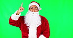 Christmas, Santa and pointing with man on green screen for presentation, idea and show.  Deal, advertising and space with portrait of person on studio background for xmas, festive and holiday season