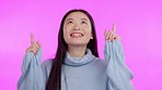 Asian woman, face and studio for pointing up, smile or excited for choice, promo and emoji by background. Japanese student girl, happy and fingers in air with dance, opinion and decision with fashion