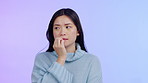 Nervous, biting nails and face of a woman on a purple background for anxiety, panic or crisis. Worried asian female person with hand while thinking of problem, mistake or mental health in studio