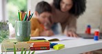 Mom, child and help with homework, color pencil and drawing for education, learning and development. Homeschool, mother and kid with motivation, support and teaching for school project in family home