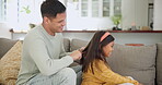 Girl, dad and brush hair with care, support and bonding with father in quality time together on couch, sofa or living room. Child, help with haircare and morning conversation with daughter and parent