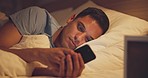 Tired, night and man with a smartphone, bed or fatigue with rest, end of the day or communication. Male person, light or guy in his bedroom, evening or cellphone with insomnia, addiction or sleepless