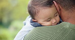 Family, garden and a baby sleeping on dad outdoor during summer while bonding together for love. Kids, care and dreaming with an infant child lying on the shoulder of a parent outside in a park