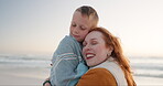 Beach, blanket and mother hug child on a holiday or vacation to be warm and bonding feeling happy. Love, care and mom support kid on cold beach or sea for travel together enjoying quality time