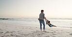 Summer, beach and a father swinging his son outdoor by the ocean while playing or bonding on vacation. Family, children and a young man having fun with his kid on the coast at sunset together