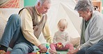 Family, toys and grandparents bonding with their grandchild in her playroom nursery at home. Playful, spending time and senior man and woman in retirement with girl kid and building blocks in bedroom