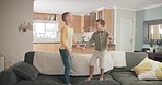 Funny, kids and boys on a couch, jump and energy with holiday, stress relief or holding hands. Male children, sofa or friends with joy, vacation or motion with activity, lounge or fun in an apartment