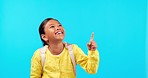 Laughing, hand pointing and happy girl child in studio with back to school sale, announcement or promo on blue background. Smile, news and kid student with kindergarten deal, coming soon or info