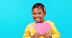 Portrait, girl with paper heart and against a blue background with a smile. Happy or excited, mockup space or romantic gesture and young female child with love poster for positivity in backdrop