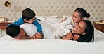 Mother, father and happy kids on bed, playing and bonding fun in family home on weekend morning. Happiness, parents and children smile in bedroom, playful quality time together and laughing with love