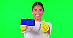Asian woman, maid and phone in thumbs up on green screen for approval against a studio background. Portrait of female person or cleaner show mobile smartphone with like emoji, yes or tracking markers