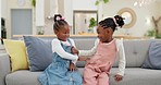 Kids, play and couch in a home with poke, smile and happy from sibling bonding together. House, lounge sofa and daughter friends with game and girl friendship with fun and youth in a living room