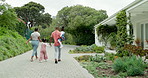 Family, holding hands and walking together to house, home and children with parents in backyard, garden or back entrance. Black couple, kids and return from holiday,  weekend or walk to door