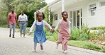 Happy, holding hands and a black family on vacation with running children in a neighborhood. Smile, love and African parents on a walk with girl kids in a street or road during a holiday together