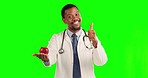 Black man, doctor and apple with thumbs up on green screen for healthcare diet against a studio background. Portrait of African male person with organic fruit and like emoji or yes sign for approval