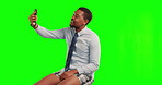 Greeting, man with smartphone and on video call against a  green screen for connectivity. Online communication or networking, social media or live streaming and black male person with cellphone