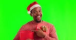 Surprise, green screen and man with a christmas box and santa claus hat with a shocked face in studio. Happy, wow and portrait of an African male model with festive xmas gift by chroma key background