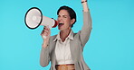 Megaphone, protest and announcement with a woman shouting in studio on a blue background for support at a rally. Noise, politics and information with a young female speaker screaming propaganda