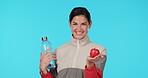 Health, face and woman with an apple on a blue background with water for nutrition and diet. Smile, wellness and portrait of girl with fruit and bottle for fitness detox isolated on a studio backdrop