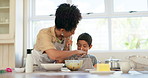 Family, mother and a child baking and learning with fun in a kitchen at home for development. Mixed race woman and boy kid helping and cooking together for quality time activity, play and bake