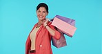 Studio, walking or face of happy woman with shopping bags on blue background with luxury clothes. Portrait, smile or rich girl with presents or fashion on discount deal or promotional sales offer 